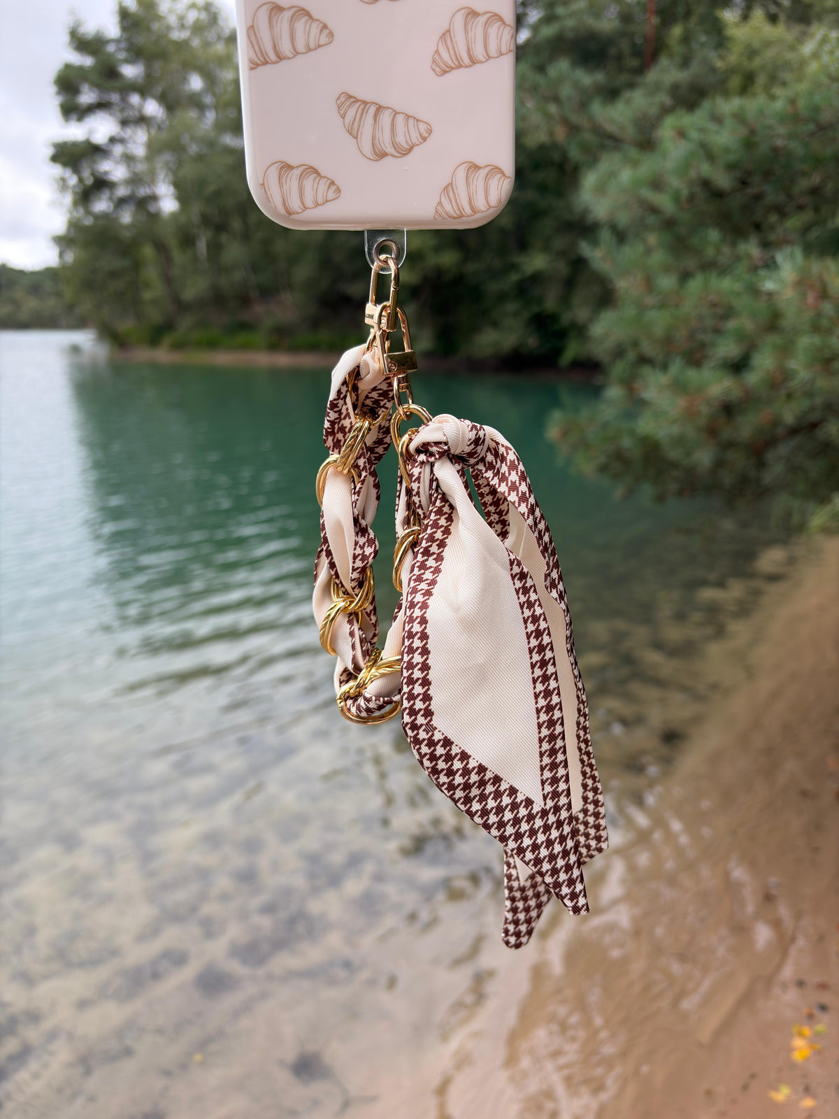 Houndstooth Chain Phone Strap detail met gouden ketting en crème pied-de-poule sjaal