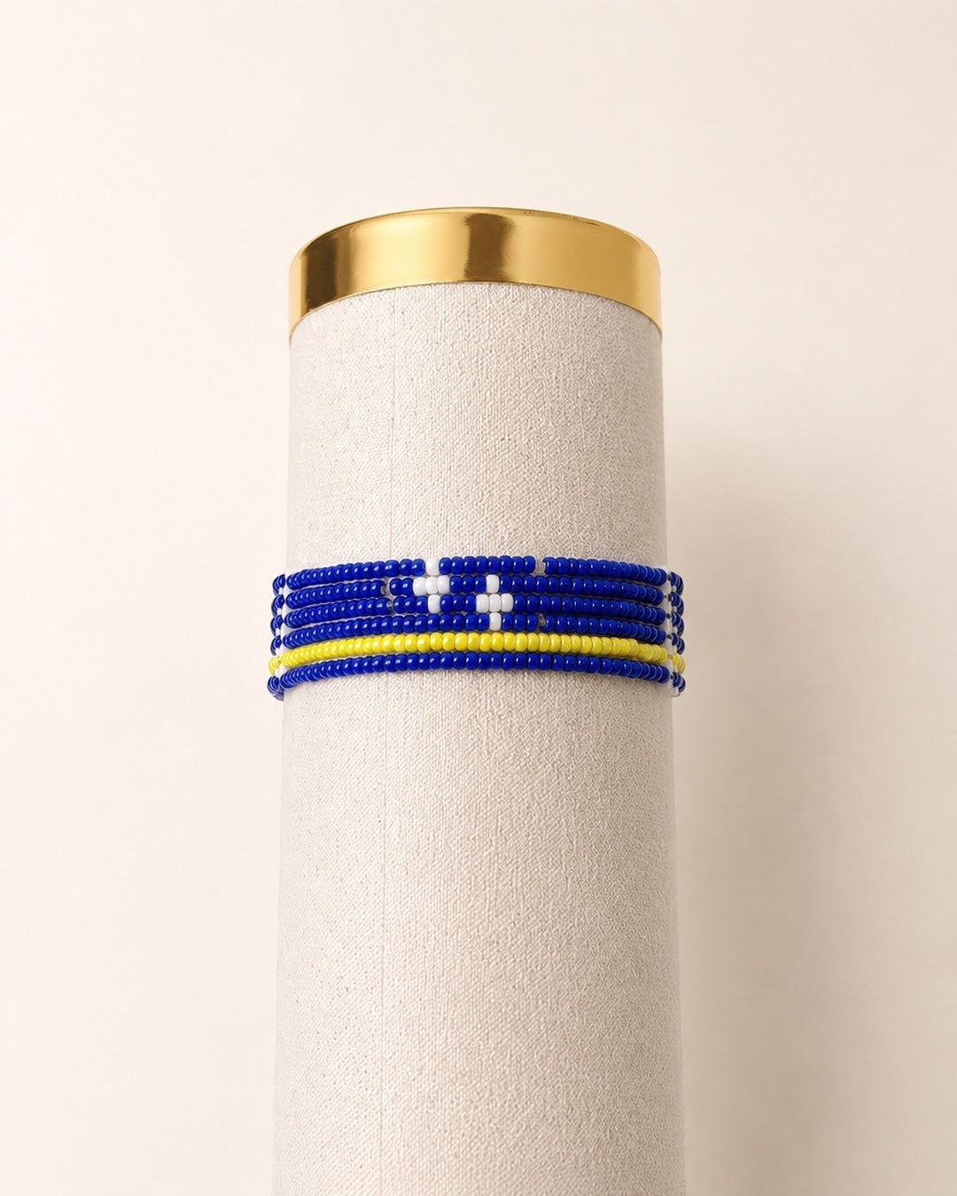 Tintabeads Curaçao armband bestaande uit zes handgemaakte kralenarmbanden in blauw, geel en wit op een display.