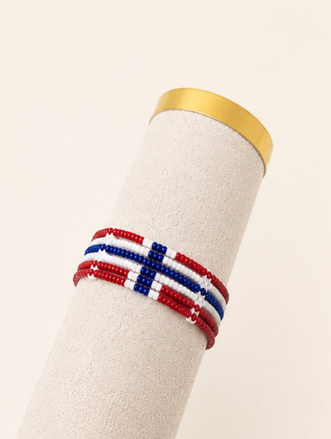 Tintabeads handgemaakte kralenarmband in rood, wit en blauw met Noorse vlagpatroon op een displaystandaard.
